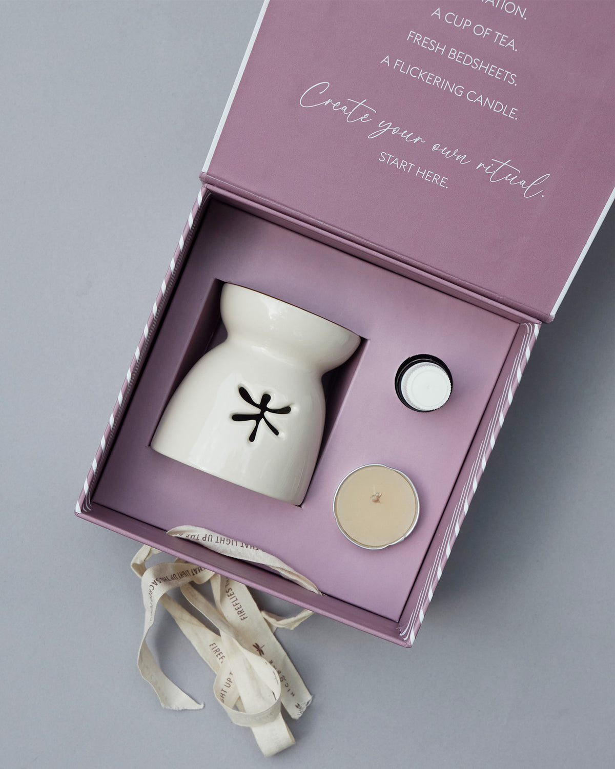 Sattva gift set in an open lilac box, with a ceramic oil burner and tealight.