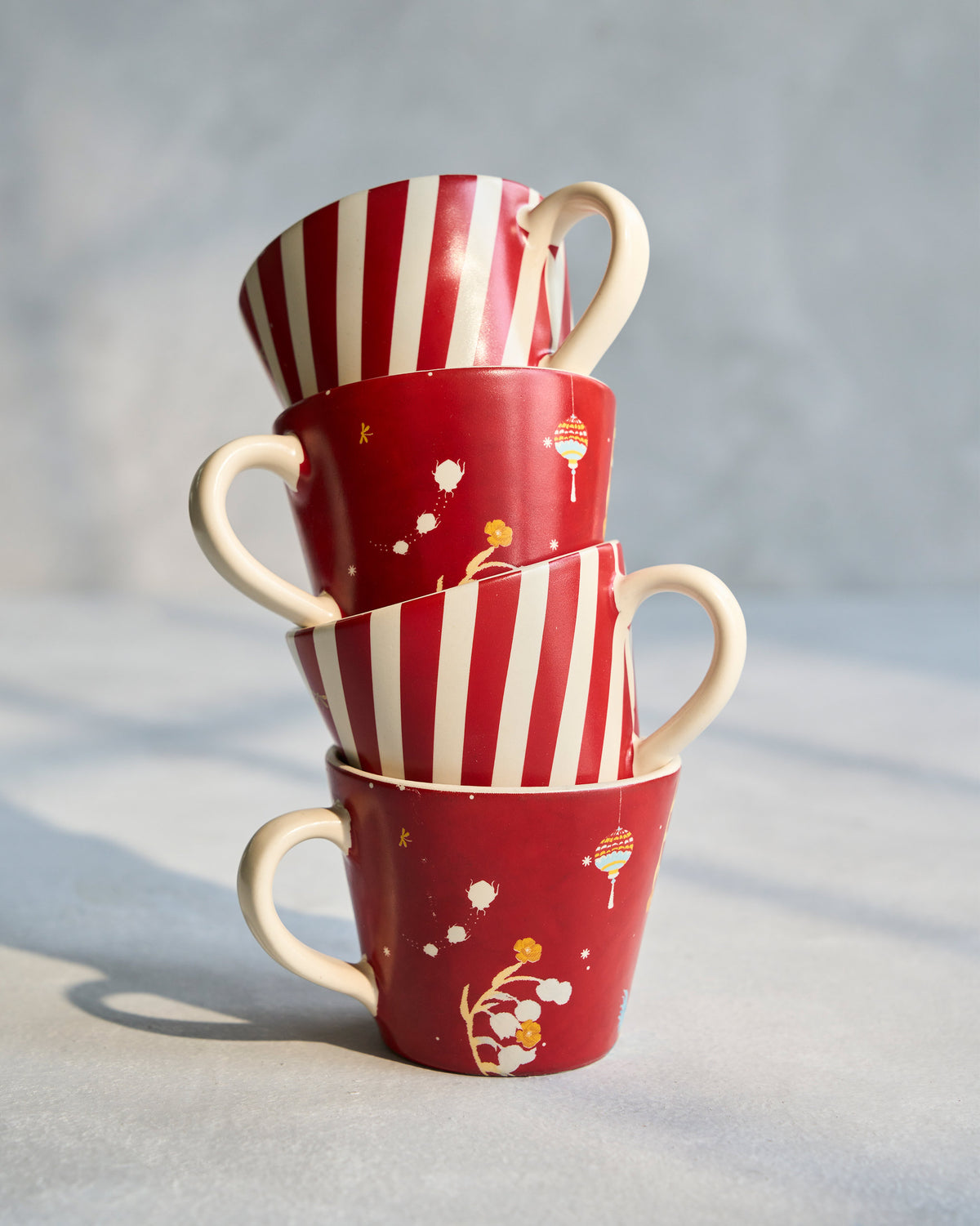 Tall stack of four Phoenix espresso mugs in alternating patterns.