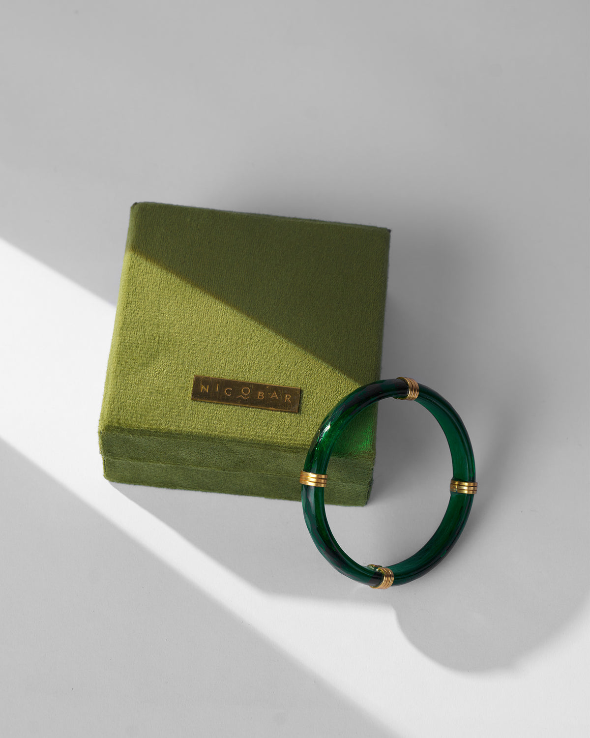Green Cara bangle with an olive Nicobar velvet gift box.