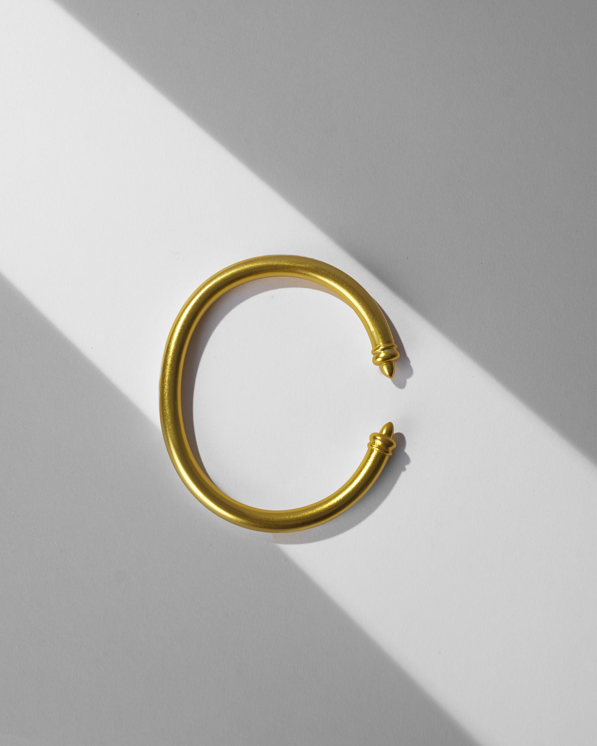 Gold Raahi open cuff bangle with pointed finials.