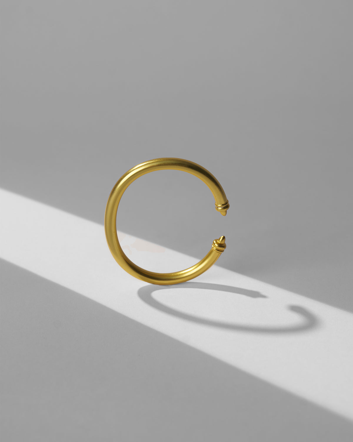 Gold Raahi open bangle standing to show its circular profile.