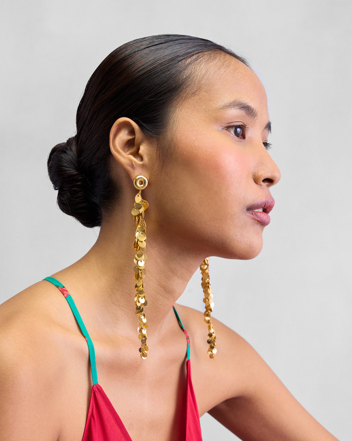 Side view of a long gold Tassel Shoulder Duster worn by a person.