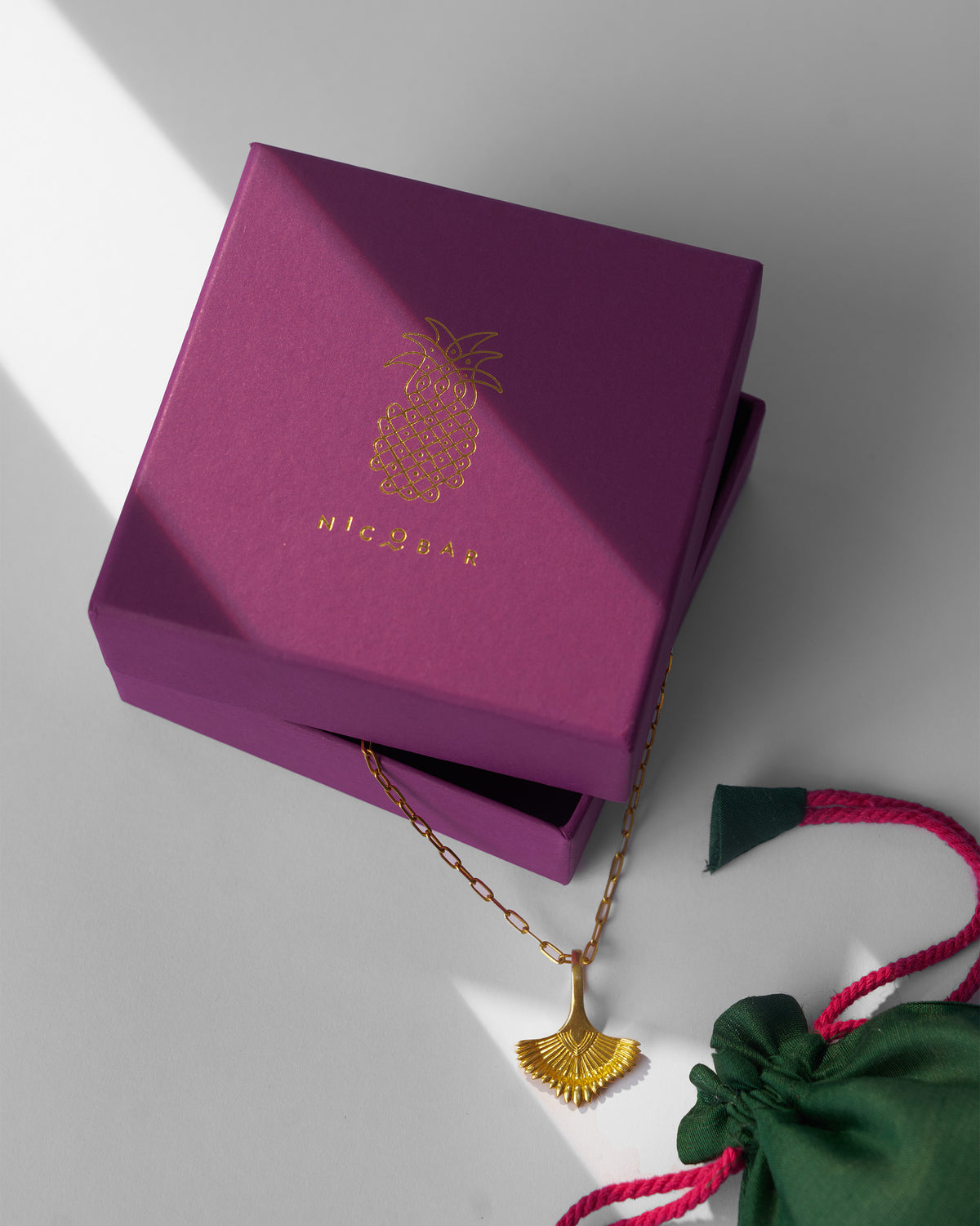 Gold palm necklace beside a Nicobar jewellery box.