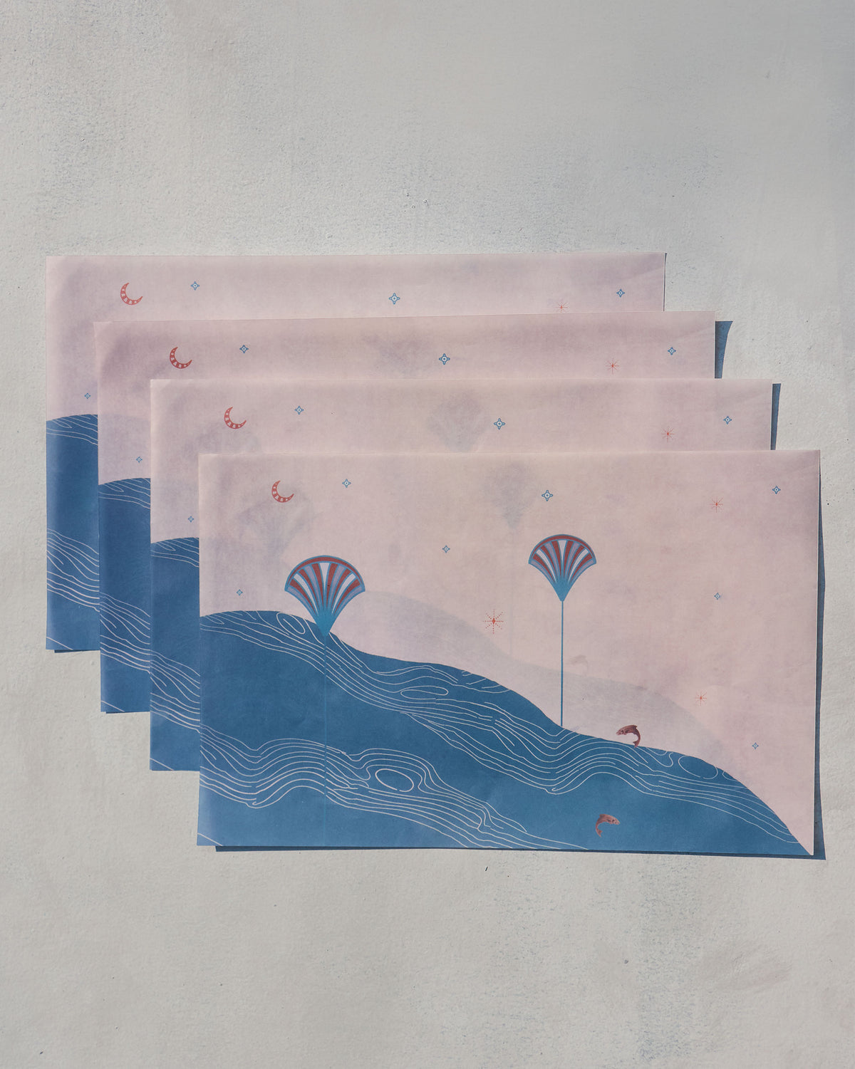 Pacific Parchment paper rectangles stacked, showing blue wave lines and fan shell motifs.