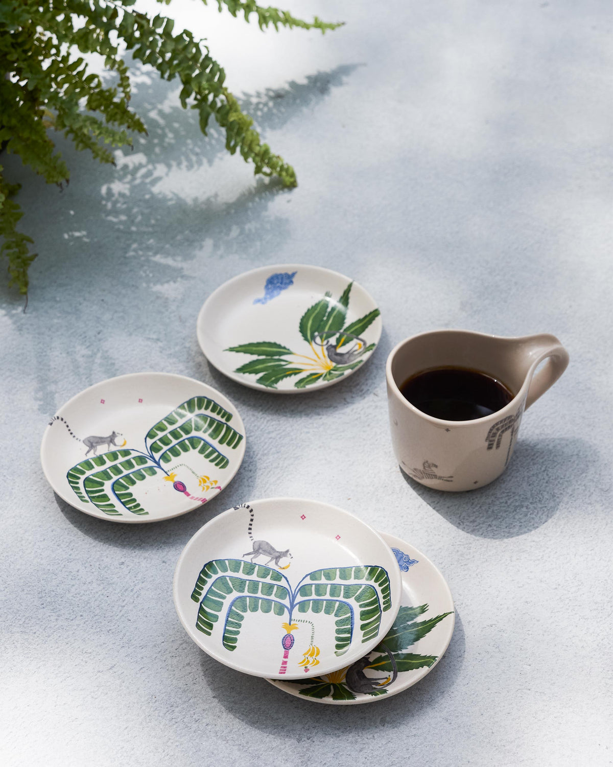 Safari tea plates styled alongside a coffee mug.