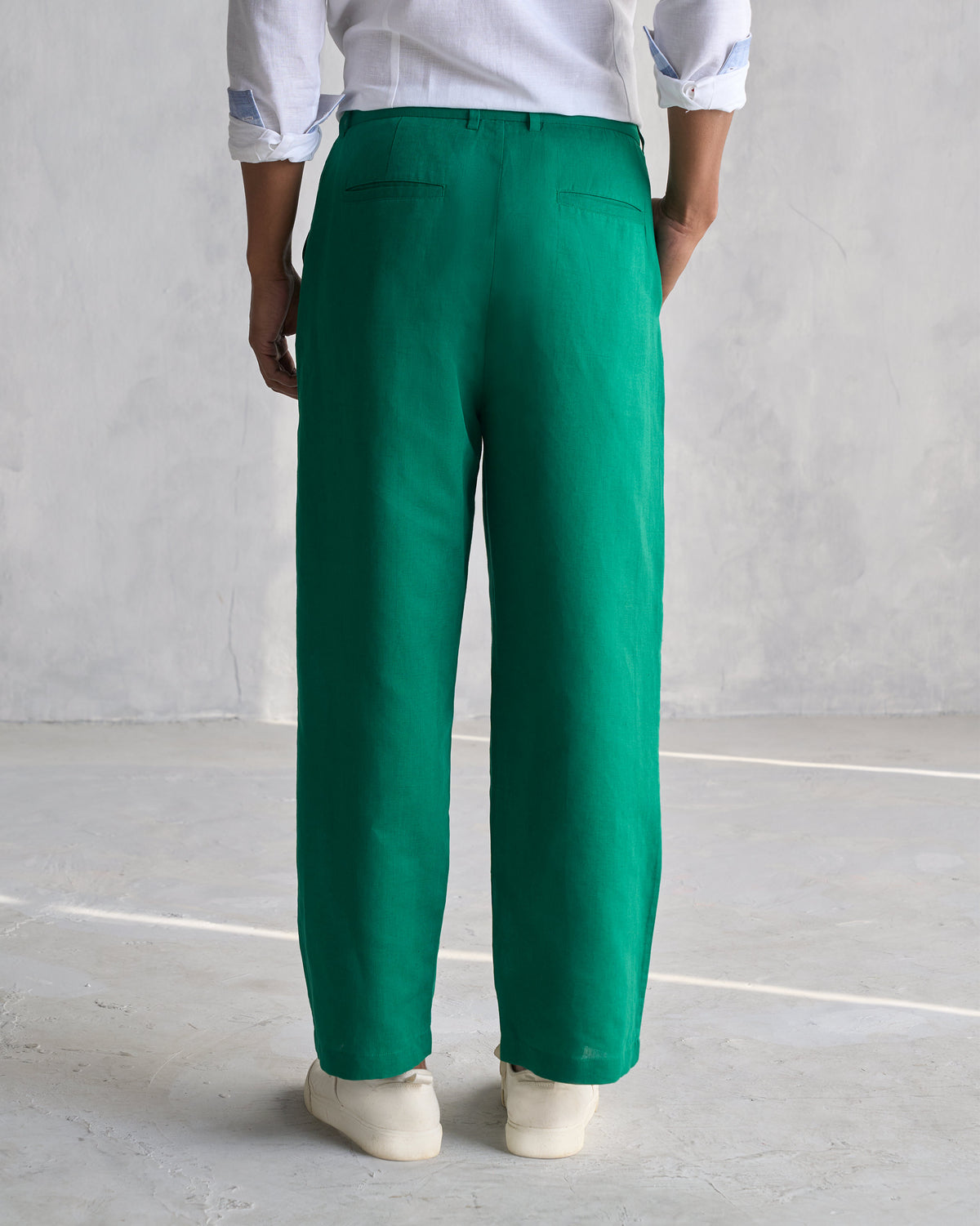 Back of green Pleated Pants showing welt back pockets.
