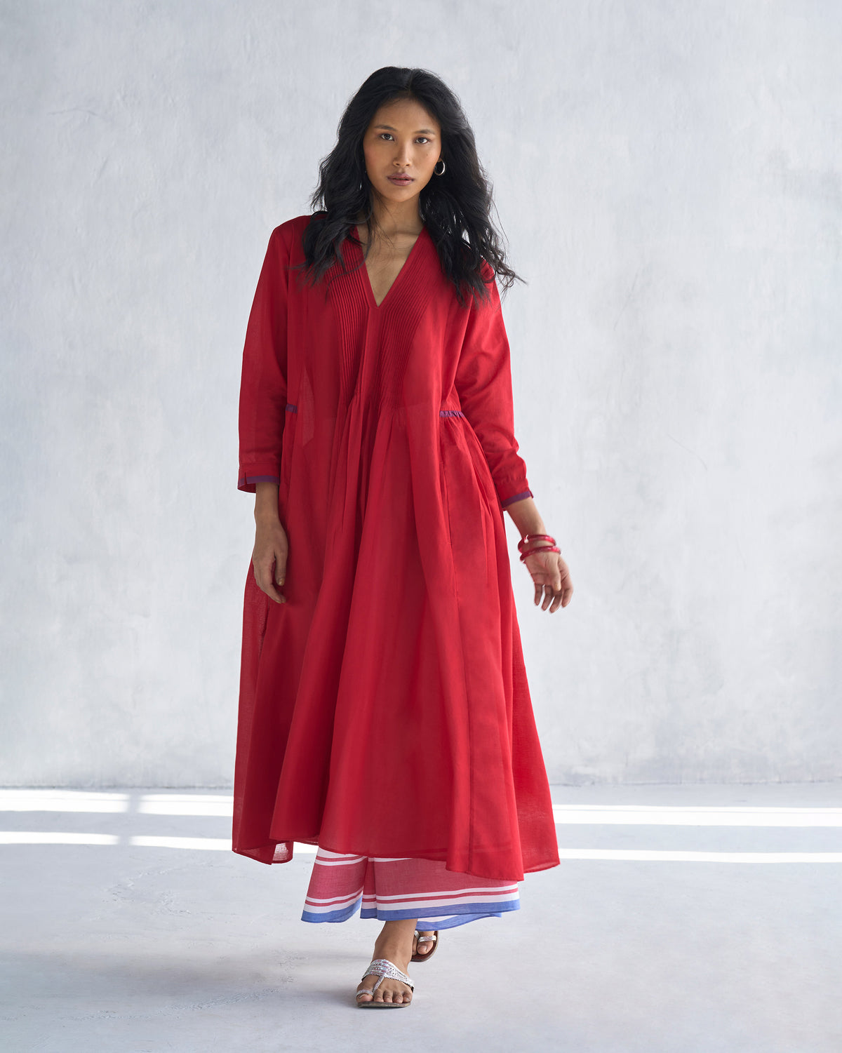 Person wearing a bright red Pintuck kurta with a V-neck and flared silhouette.