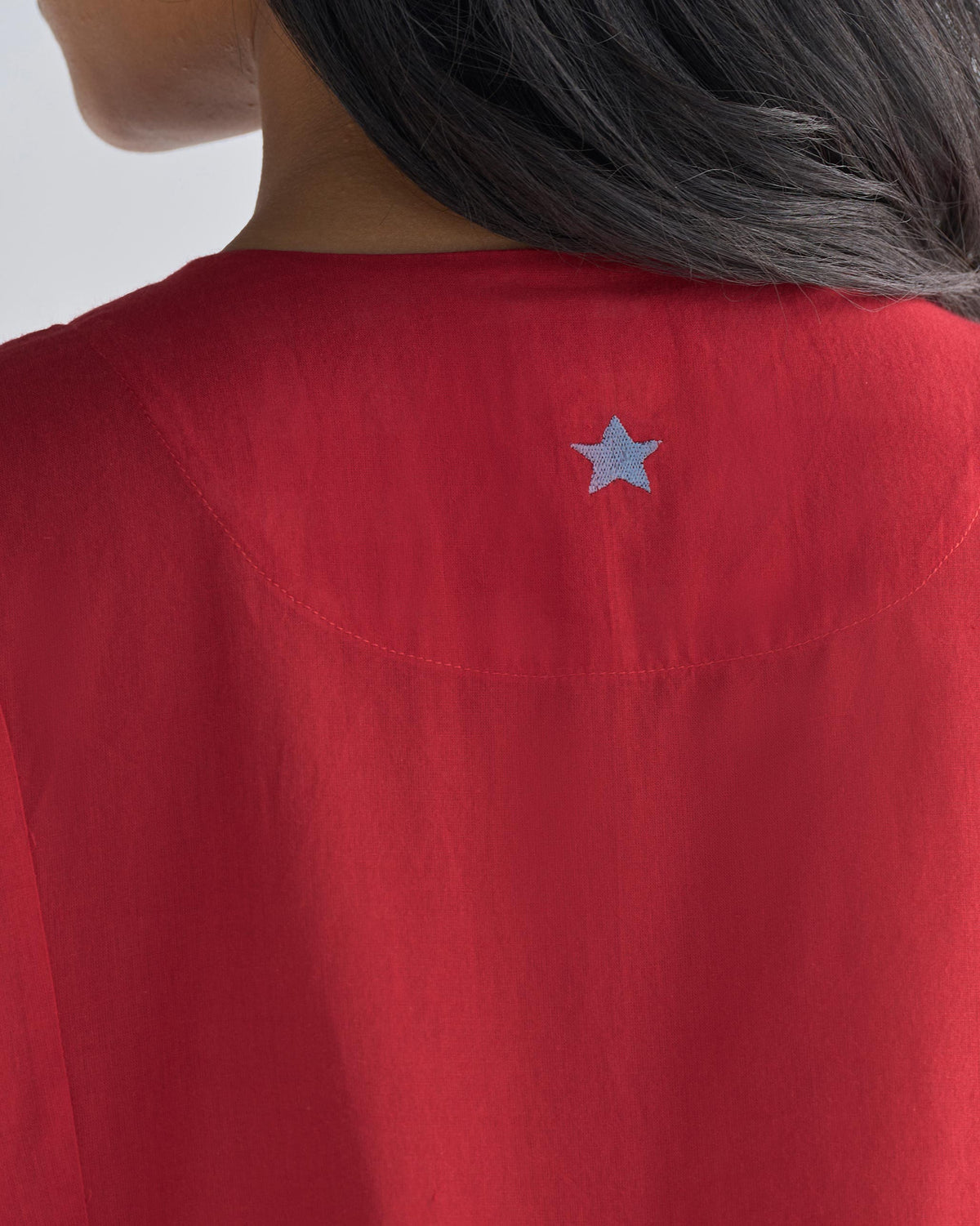 Close-up of a red Pintuck kurta back with a light blue embroidered star.