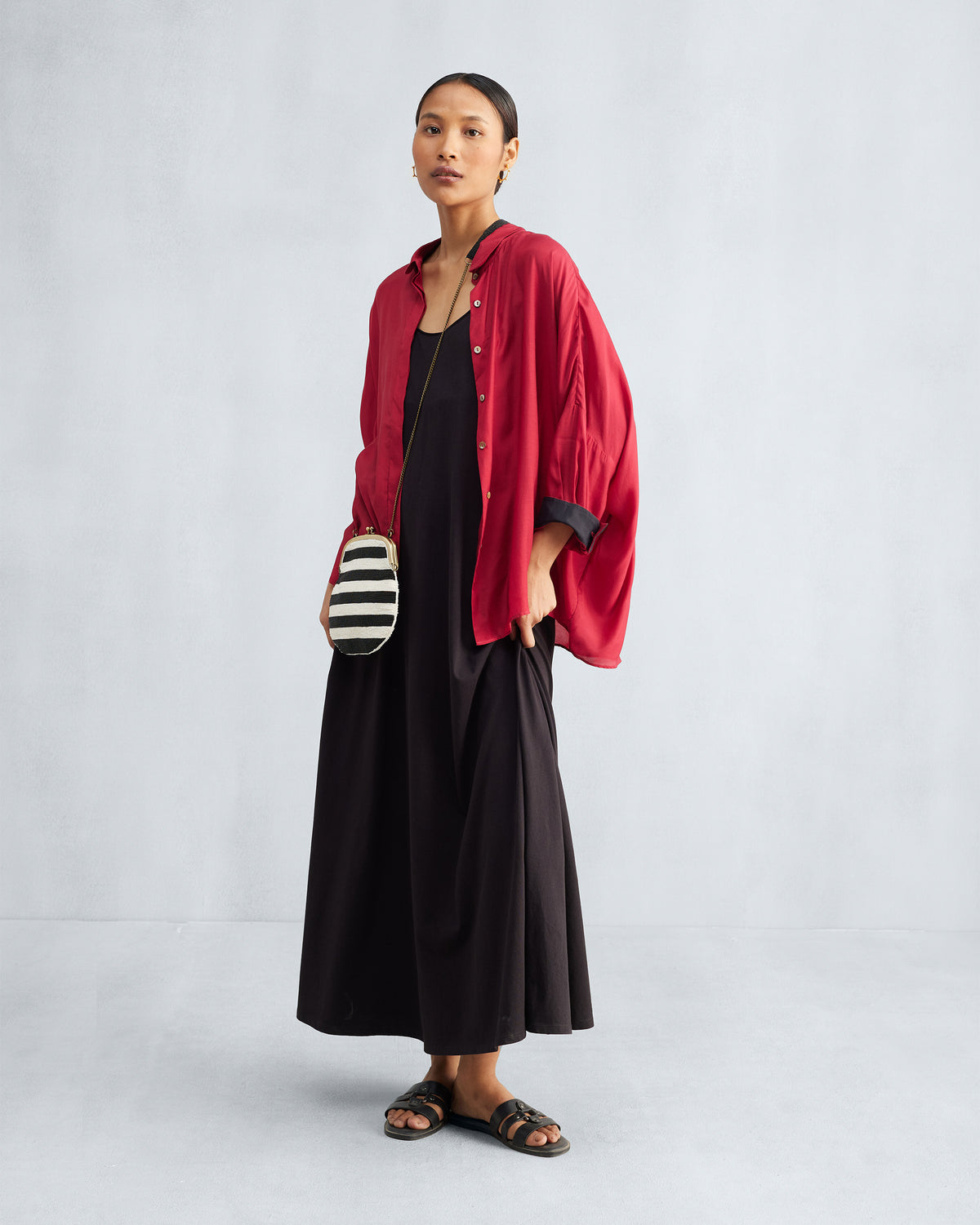 Black Esther dress styled under an open red shirt.