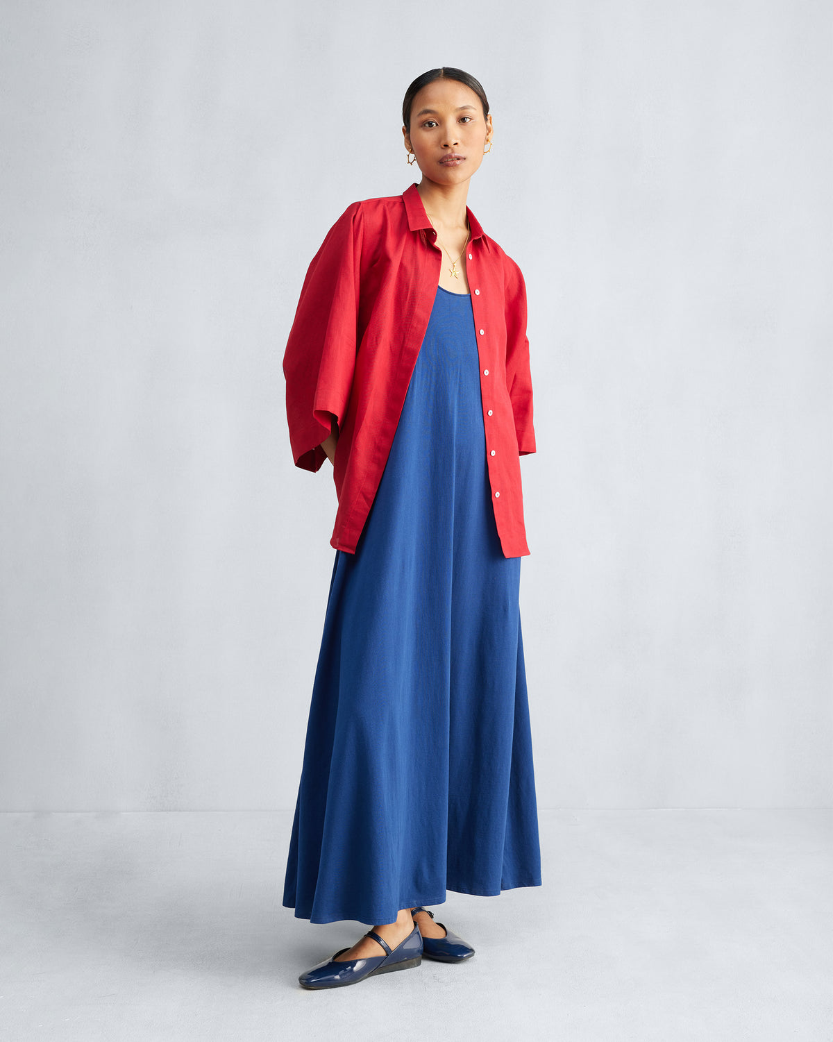 Navy Esther dress styled under an open red shirt.