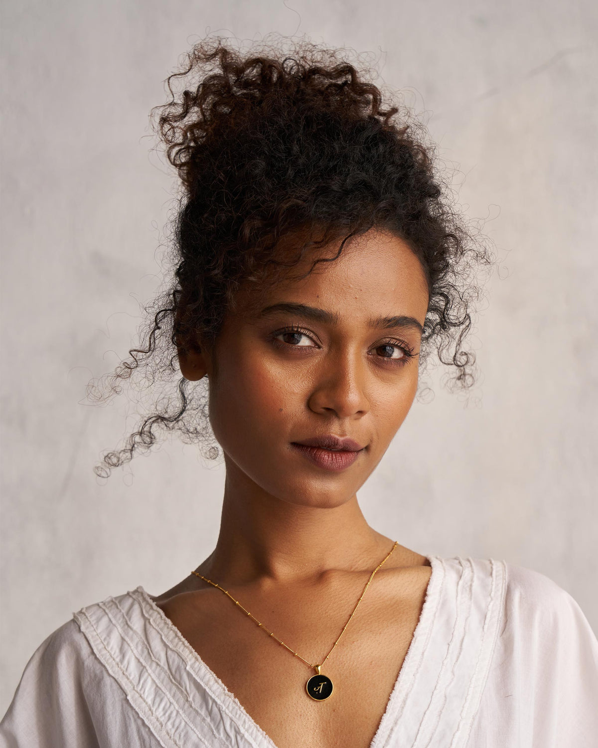 Person wearing a black and gold Alphabet Z charm necklace.