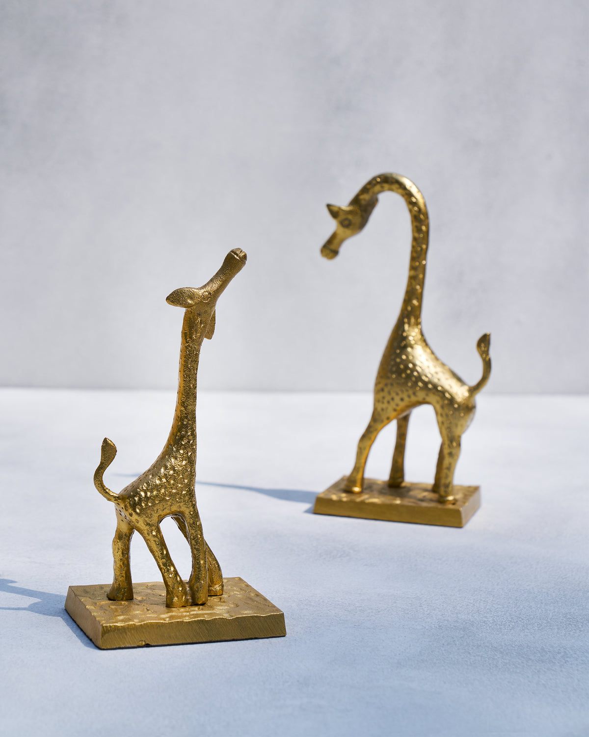 Angled view of Giraffe bookends showing hammered gold texture and facing poses.