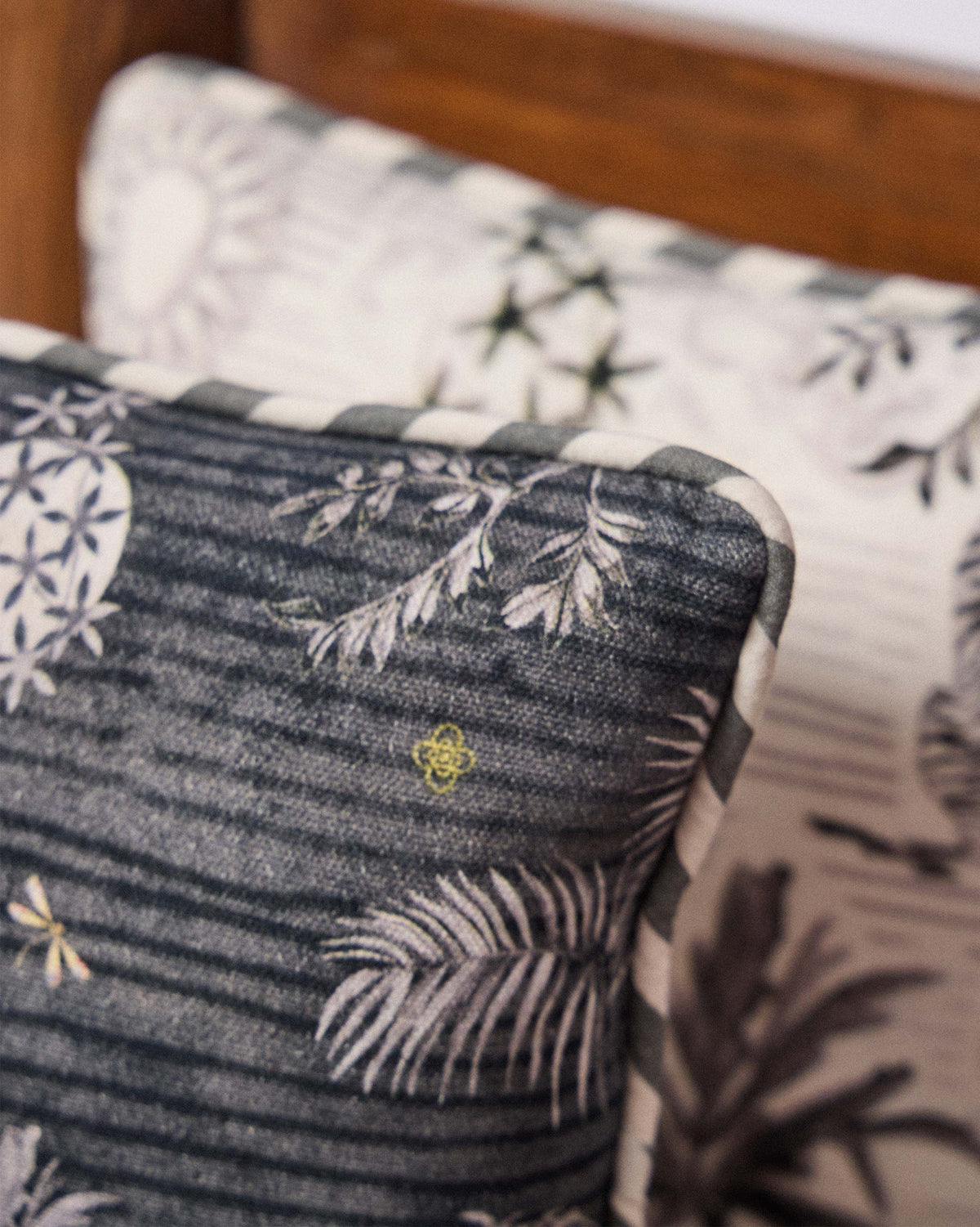 Close-up of Charcoal Ele Car Cushion showing grey palm fronds and leaf motifs.