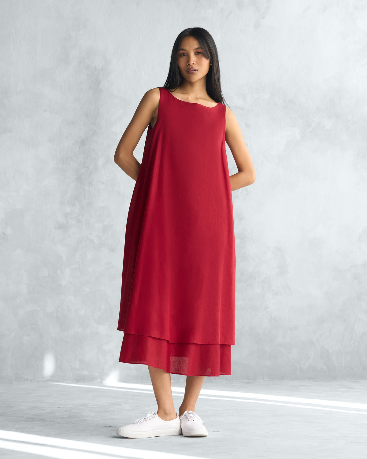 Person wearing a red Double layer dress with a layered hem.