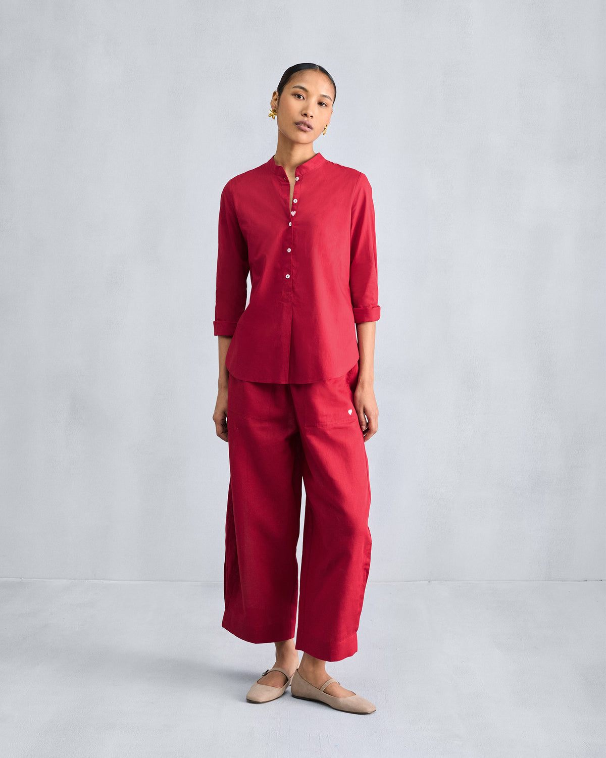Person wearing a red Mandarin Collar Top with a short button placket.