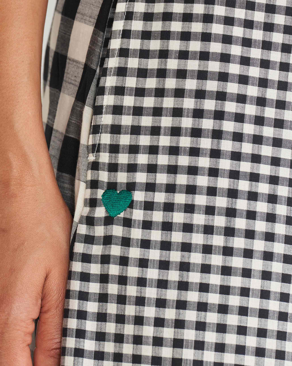 Close-up of a green heart on ivory and black gingham fabric.