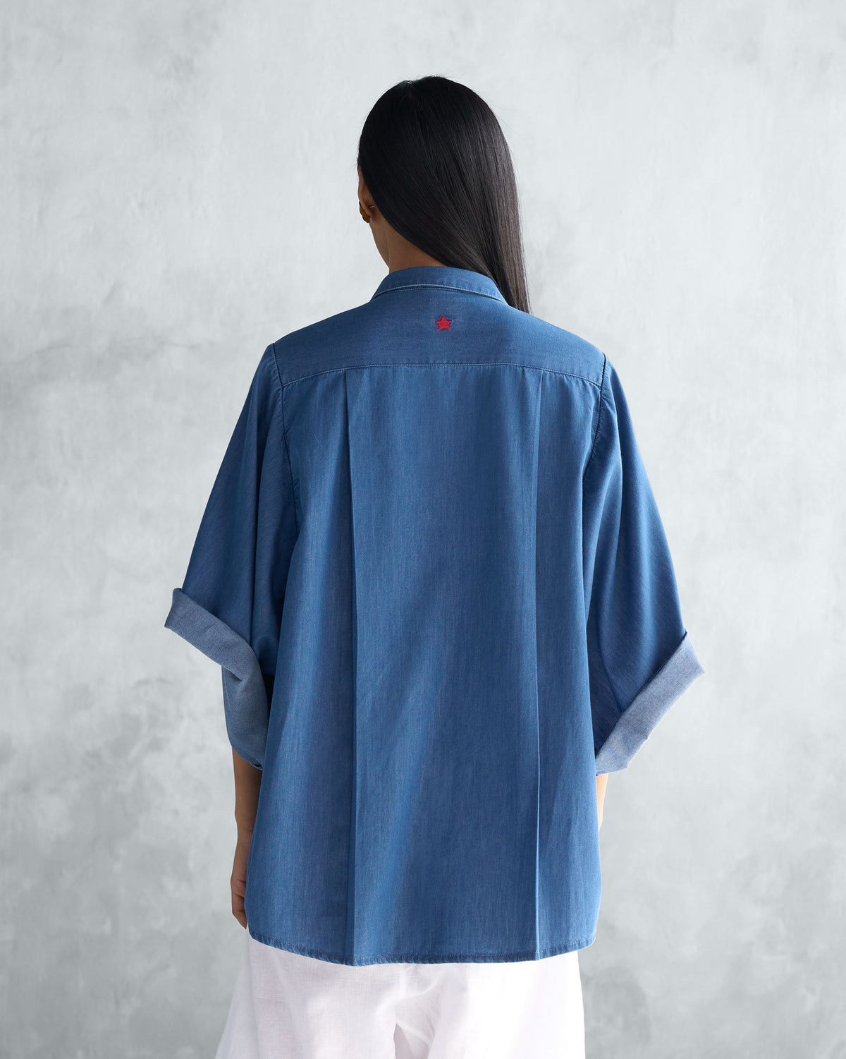 Back of the blue Drop Armhole Shirt worn by a person.