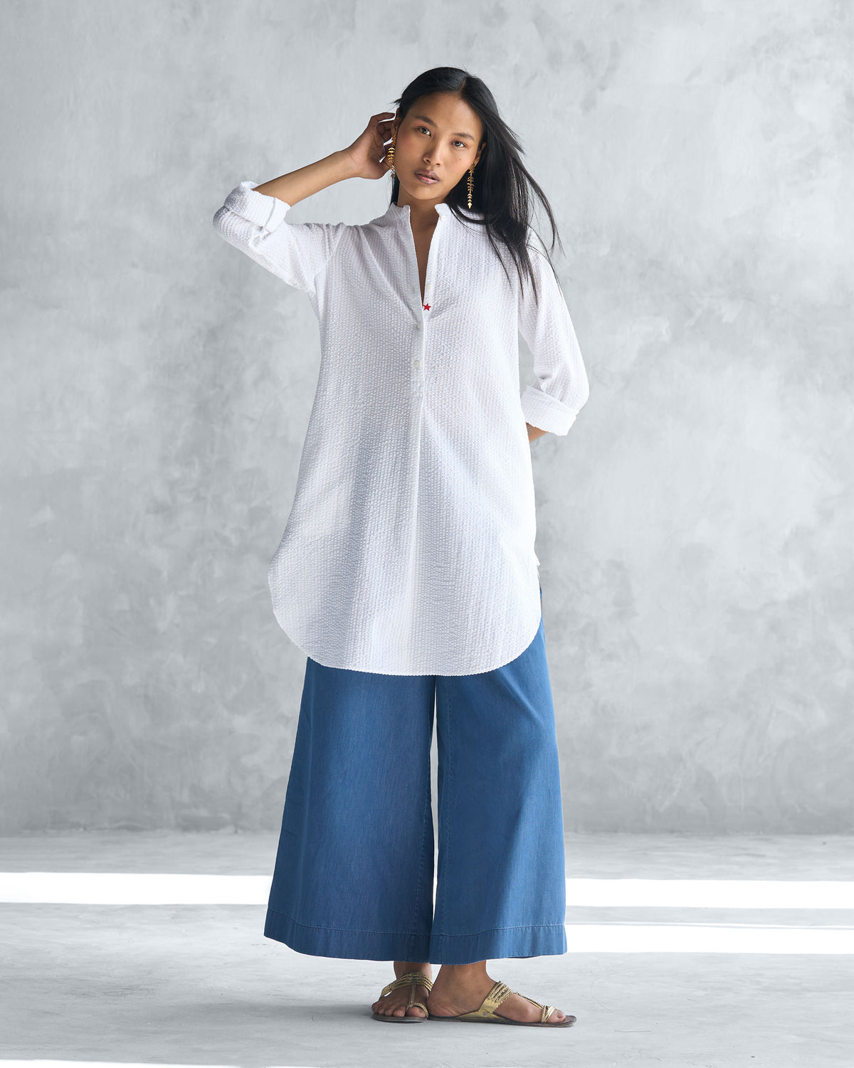 Person wearing a white seersucker mid-length kurta with a mandarin collar.