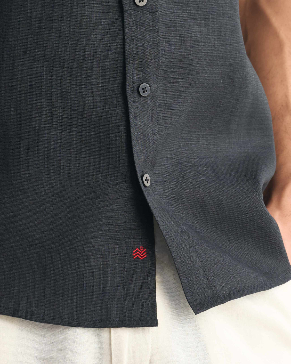 Black half sleeve shirt with a red wave logo at the hem.