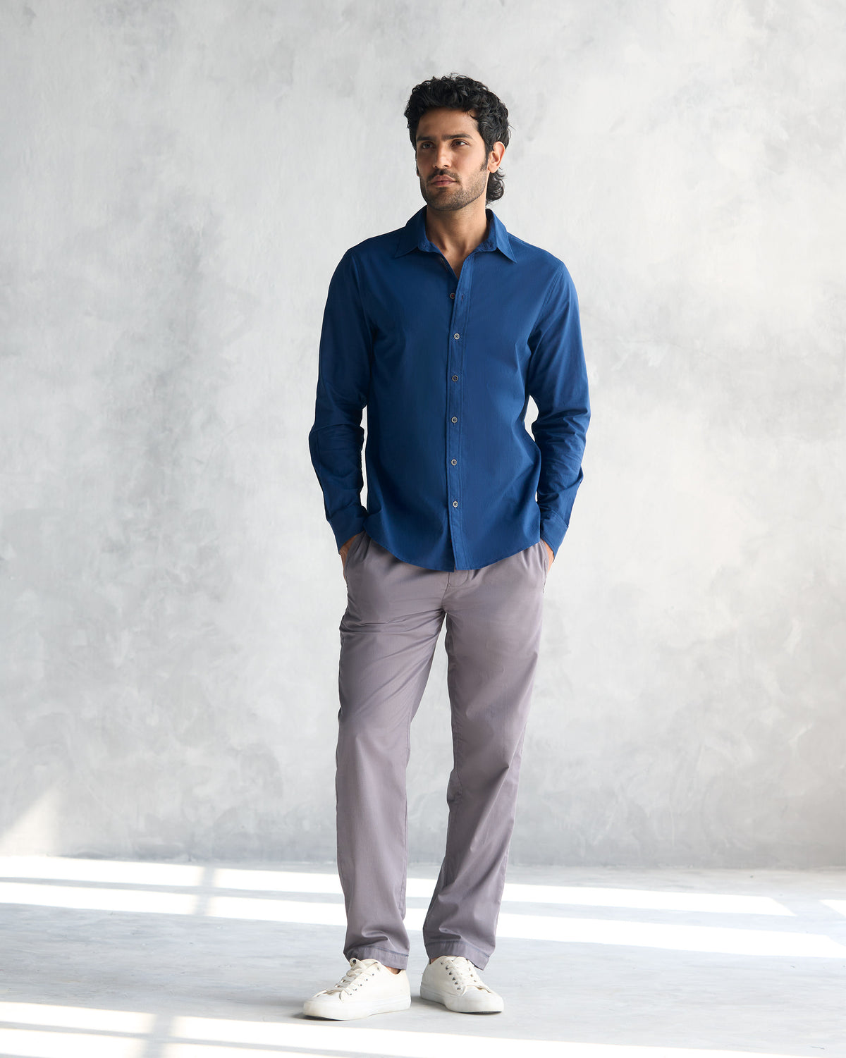 Person wearing a navy Classic Shirt untucked at full length.