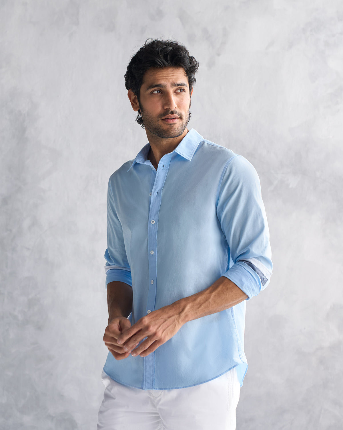 Person wearing a light blue classic shirt.