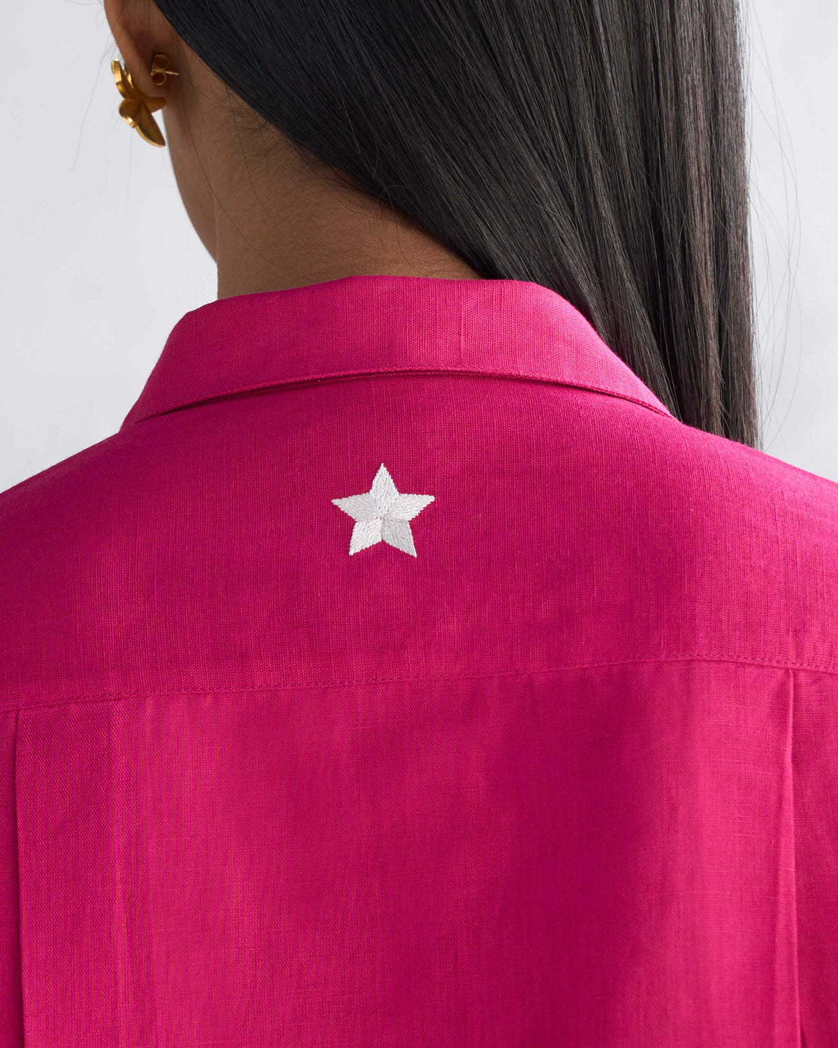 Close-up of a berry Drop Armhole Shirt back showing a white star embroidery.