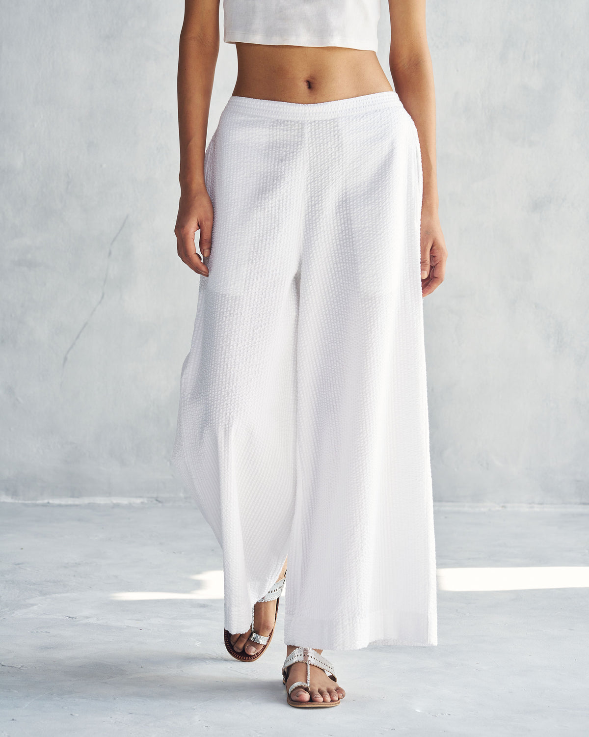 Person wearing white seersucker Basic Pyjamas with a wide-leg cut.