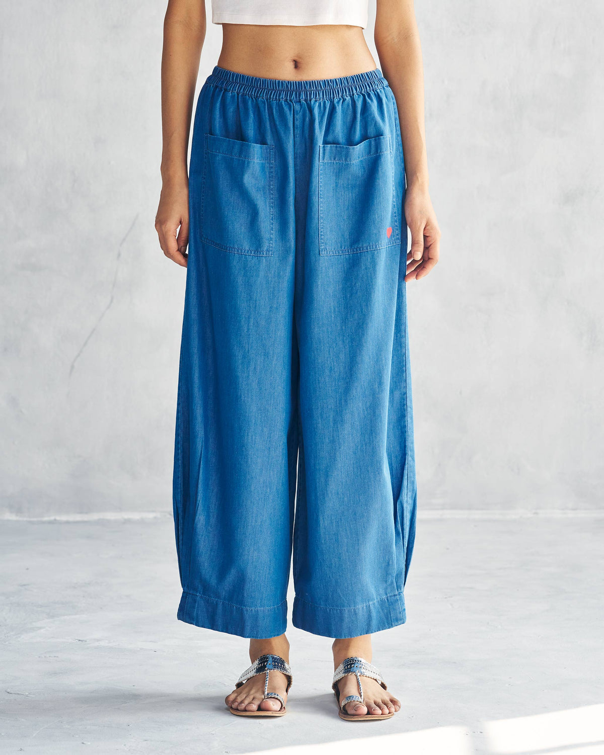 Person wearing blue Serene pants with front patch pockets and a wide-leg crop.