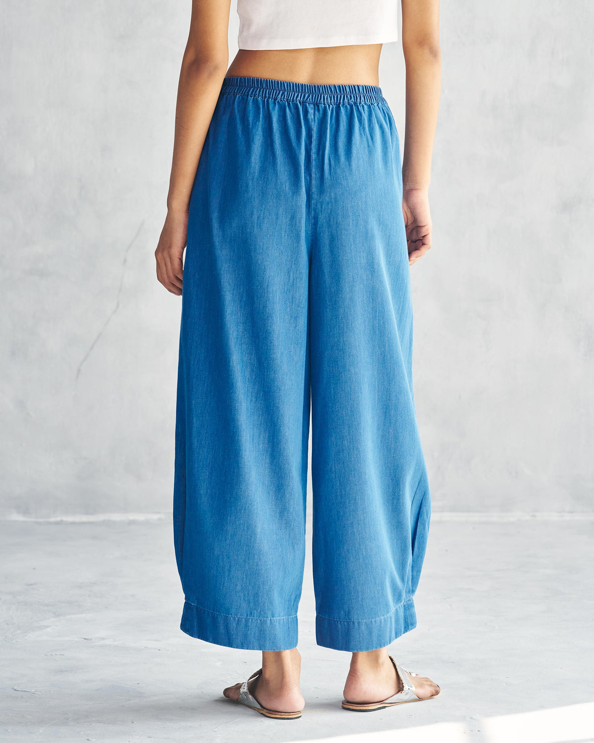 Back of blue Serene pants with an elastic waistband and cropped wide legs.