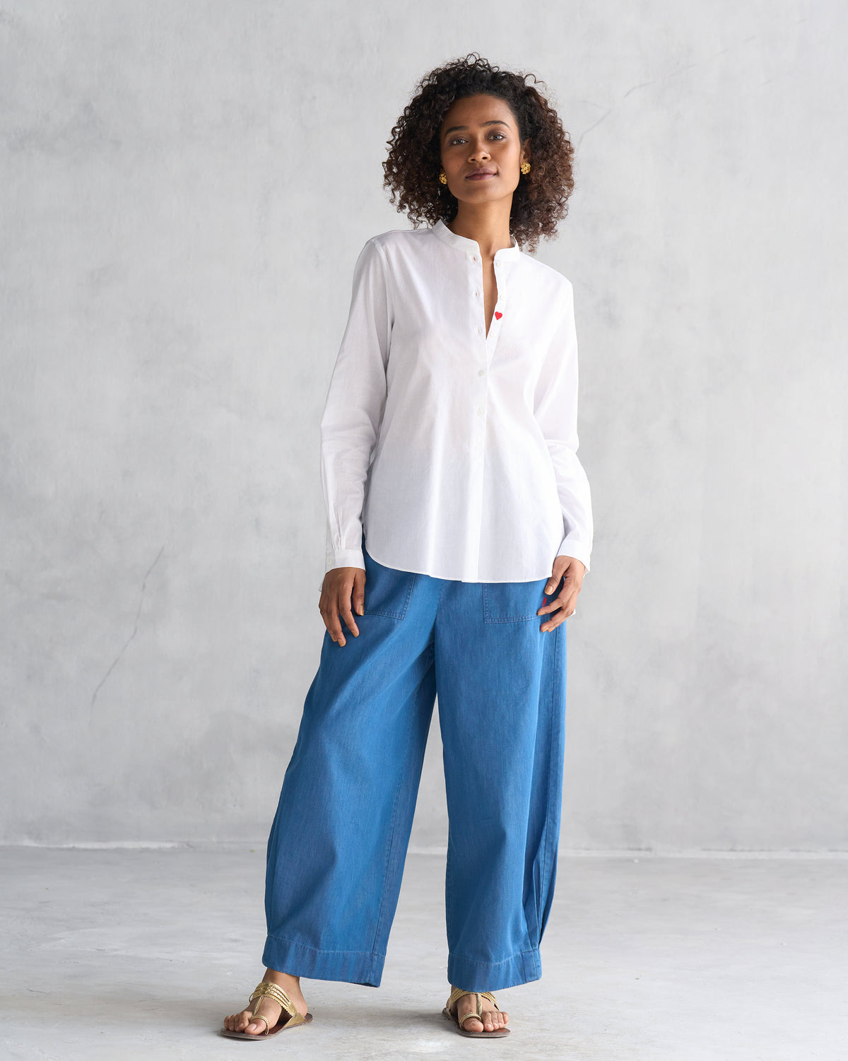 Person wearing blue Serene pants with a white mandarin collar shirt.