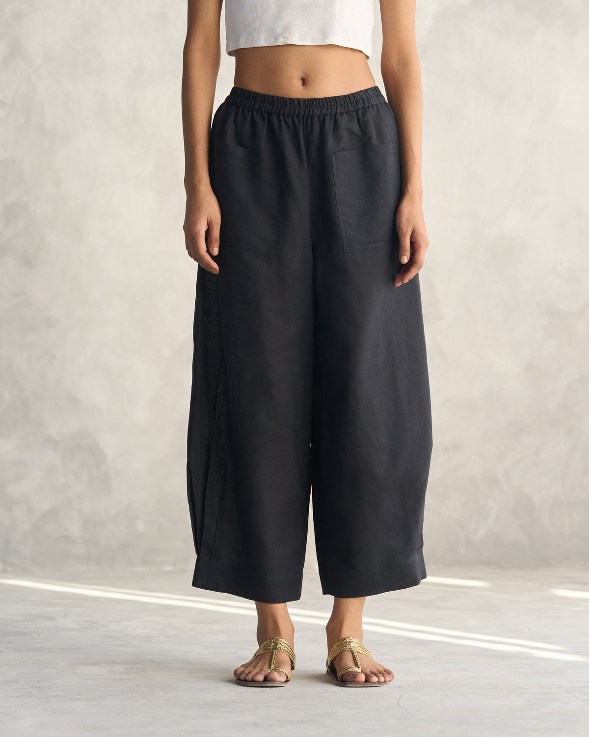 Person wearing black Serene pants with wide legs and patch pockets.
