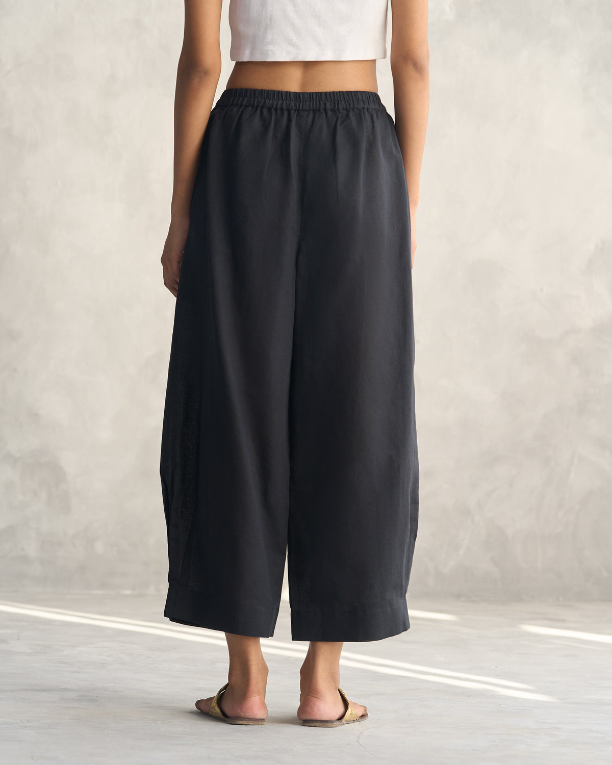 Back of black Serene pants worn by a person.