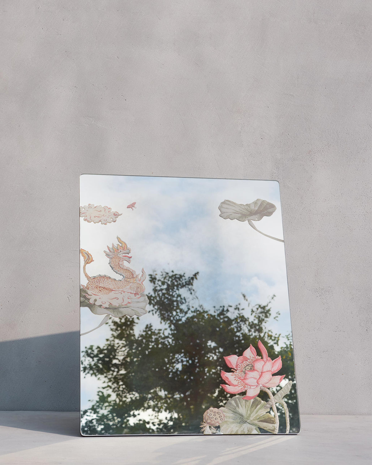 Lotus Mirror leaning against a wall, with a dragon and lotus design.