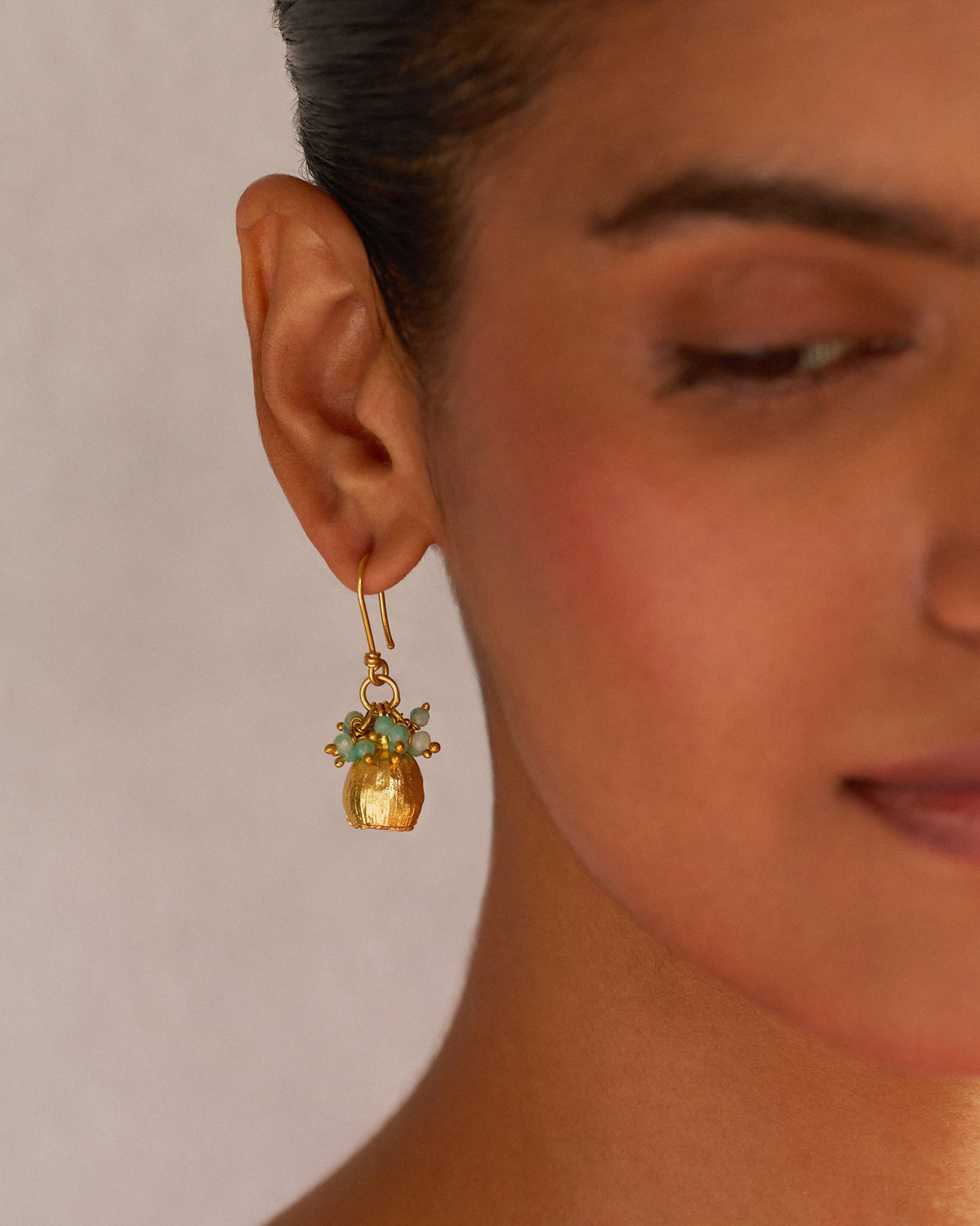 Person wearing a Himalayan Poppy Drops earring with blue-green beads.