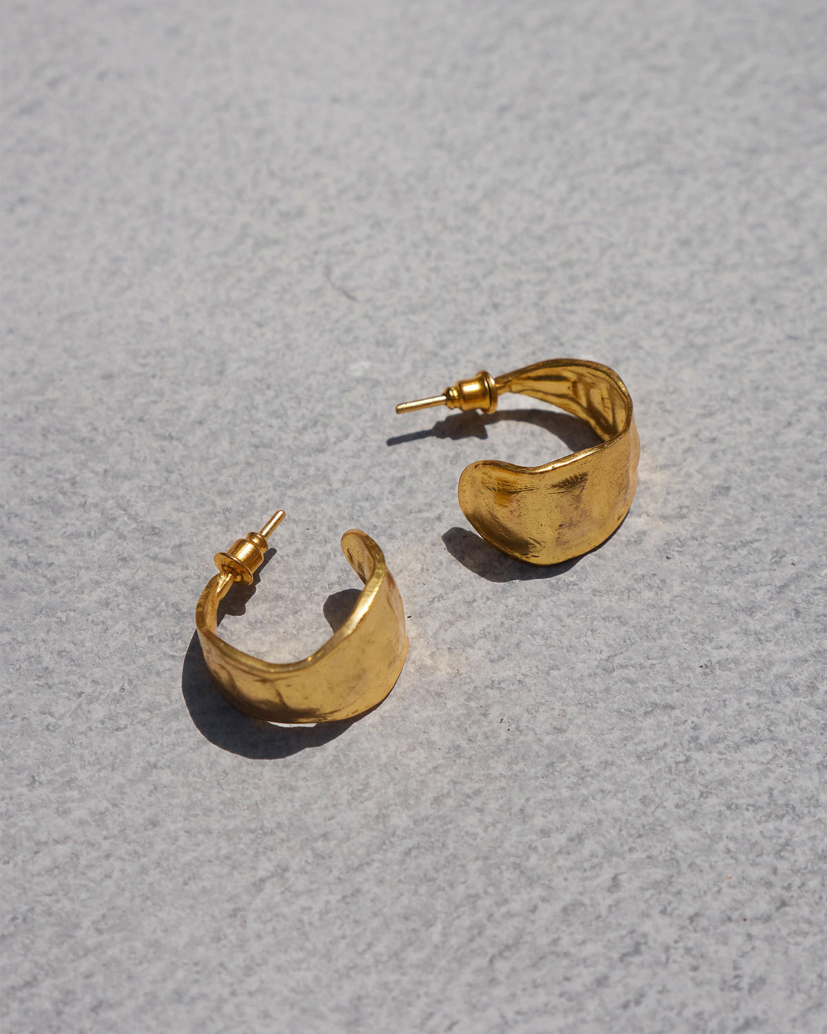 Pair of gold Seed Pod Small Hoops laid flat.