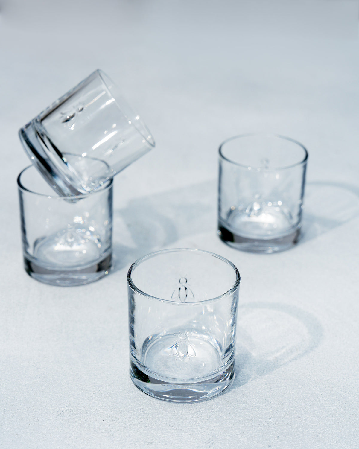 Bumble Bee whiskey glasses clustered with one tilted against another.