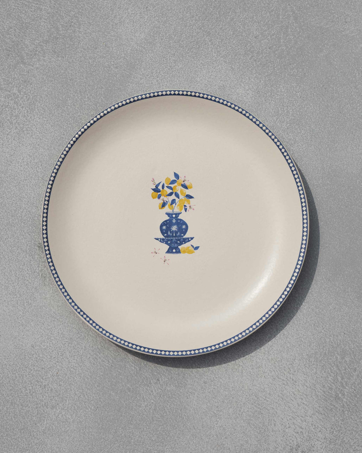 Sahara Dinner Plate with a blue vase and lemon motif at its centre.