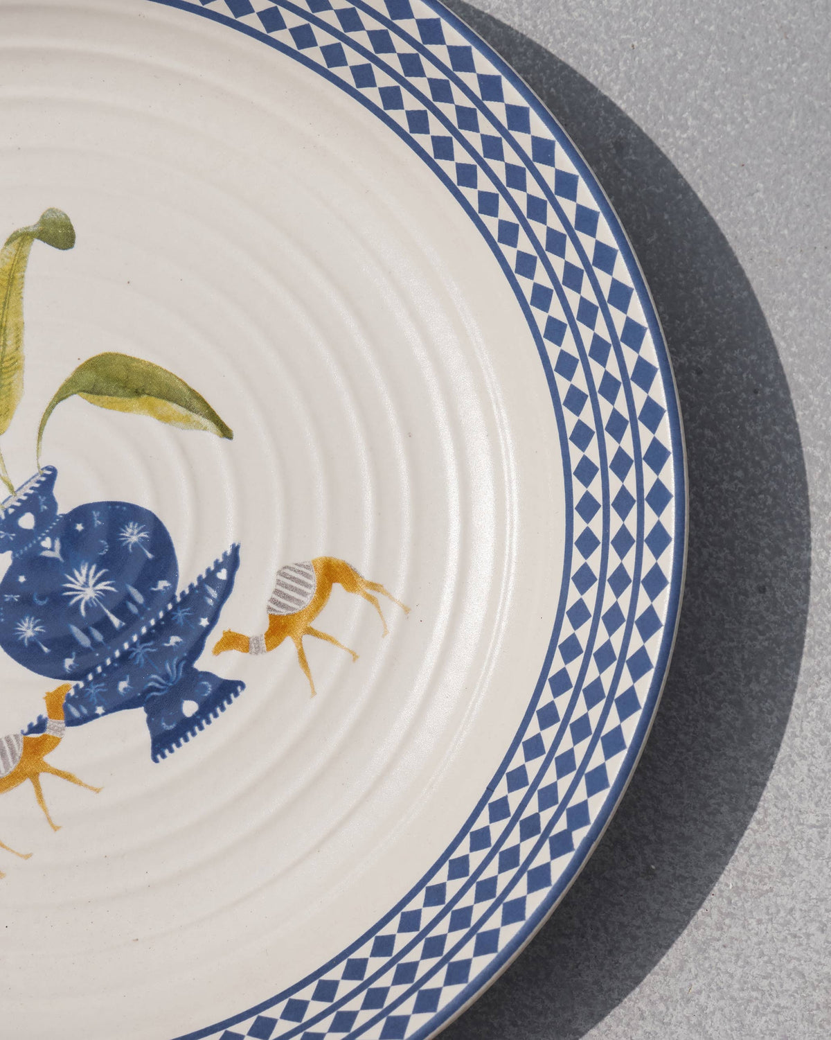 Close-up of the Sahara pasta plate's diamond-patterned rim and orange animals.