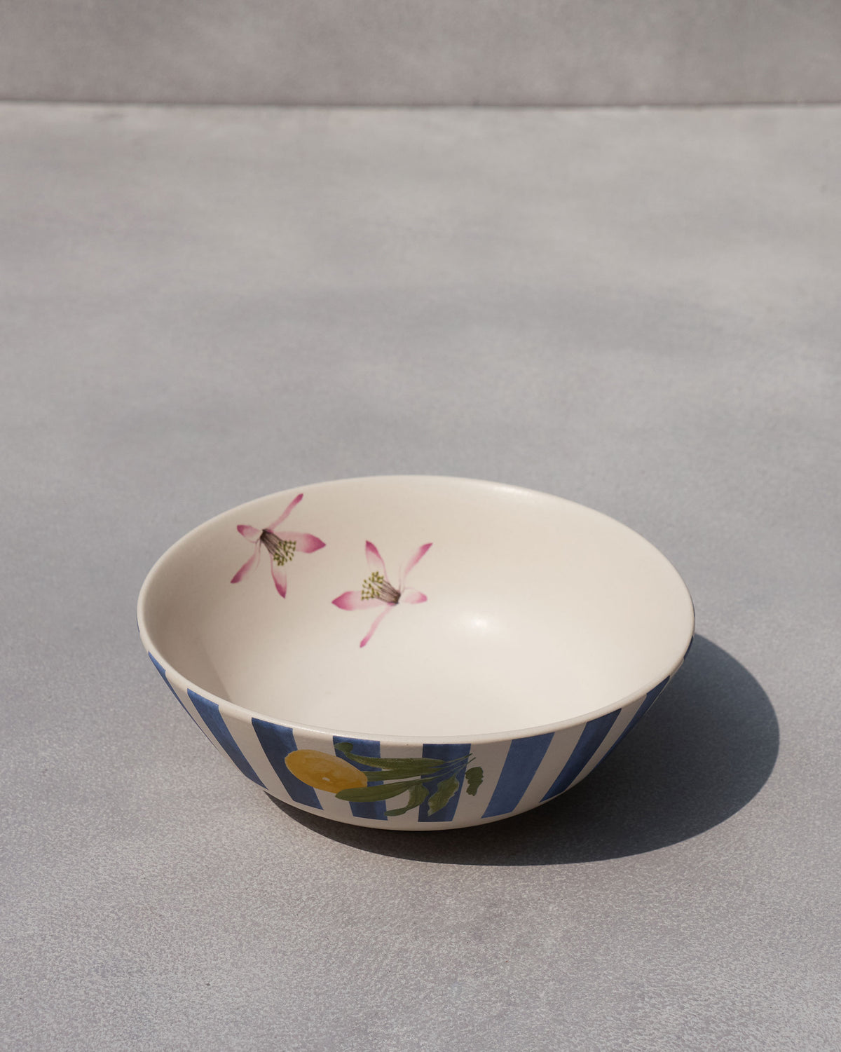 Side view of Asfar curry bowl with blue stripes and a lemon motif.