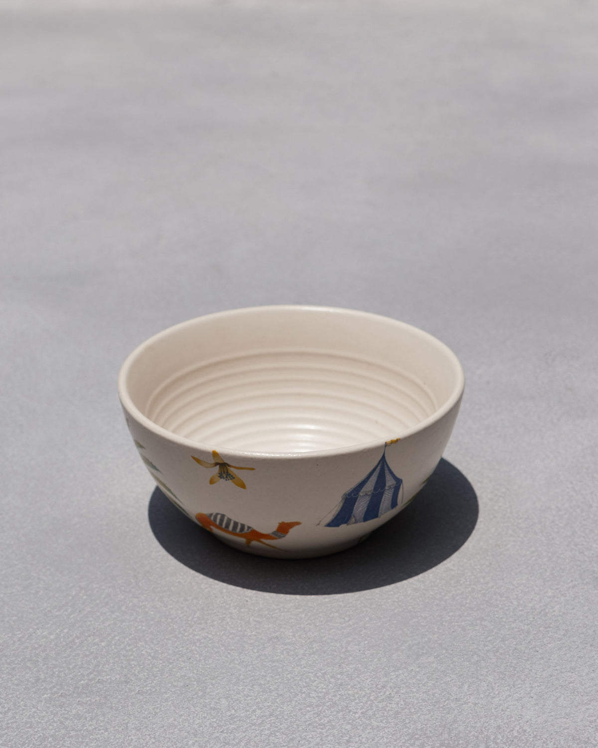 Asfar Cereal Bowl with a blue striped tent and orange animal motifs.