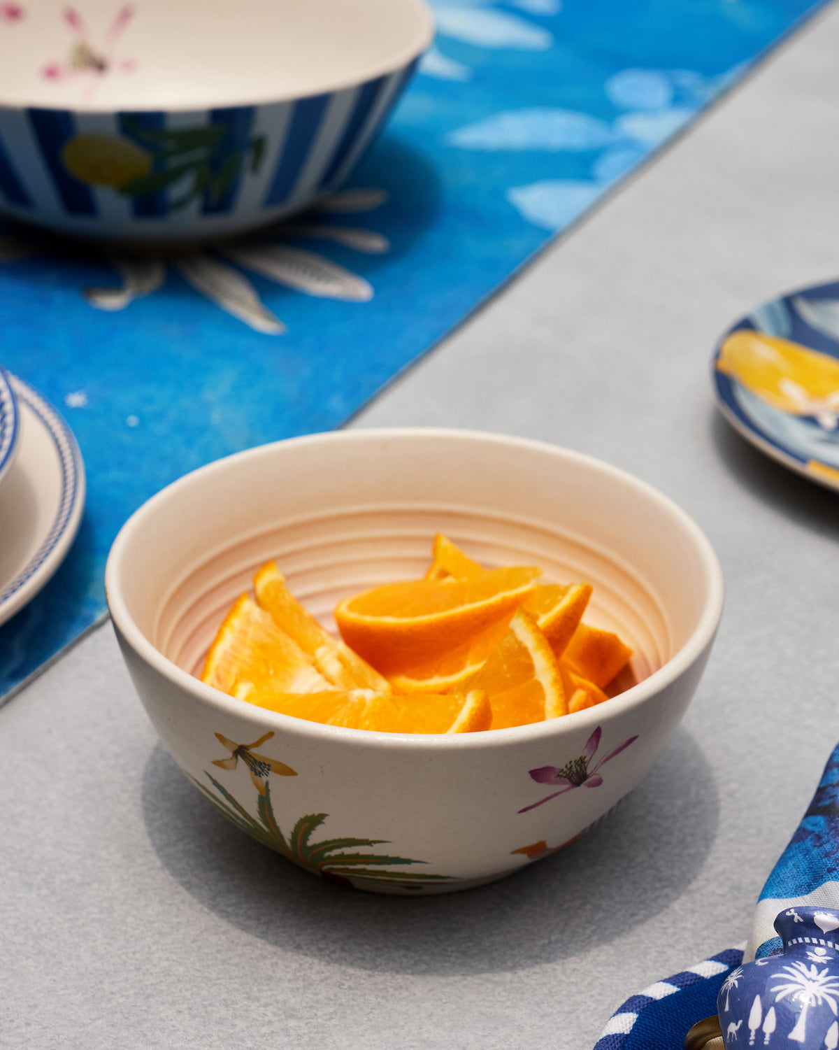Asfar Cereal Bowl filled with orange peel, with a painted palm on the outside.