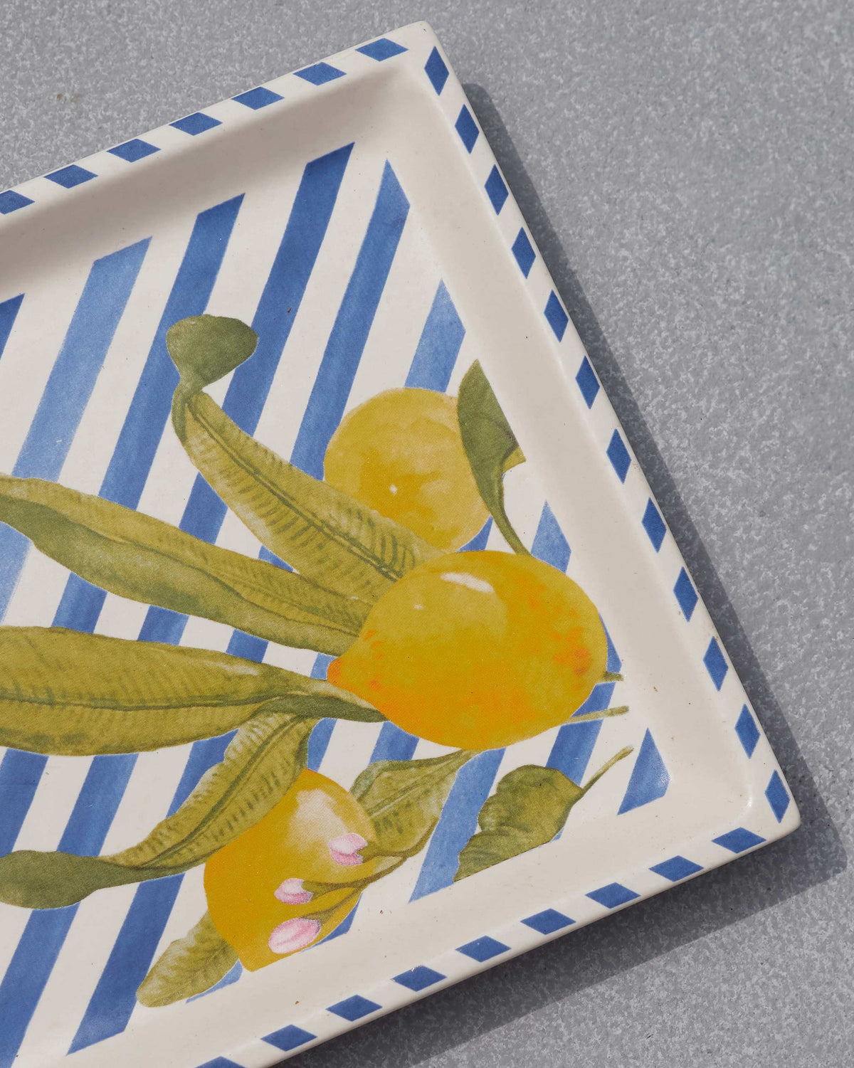 Close-up of lemon and leaf motifs on the blue-striped Asfar cookie tray.