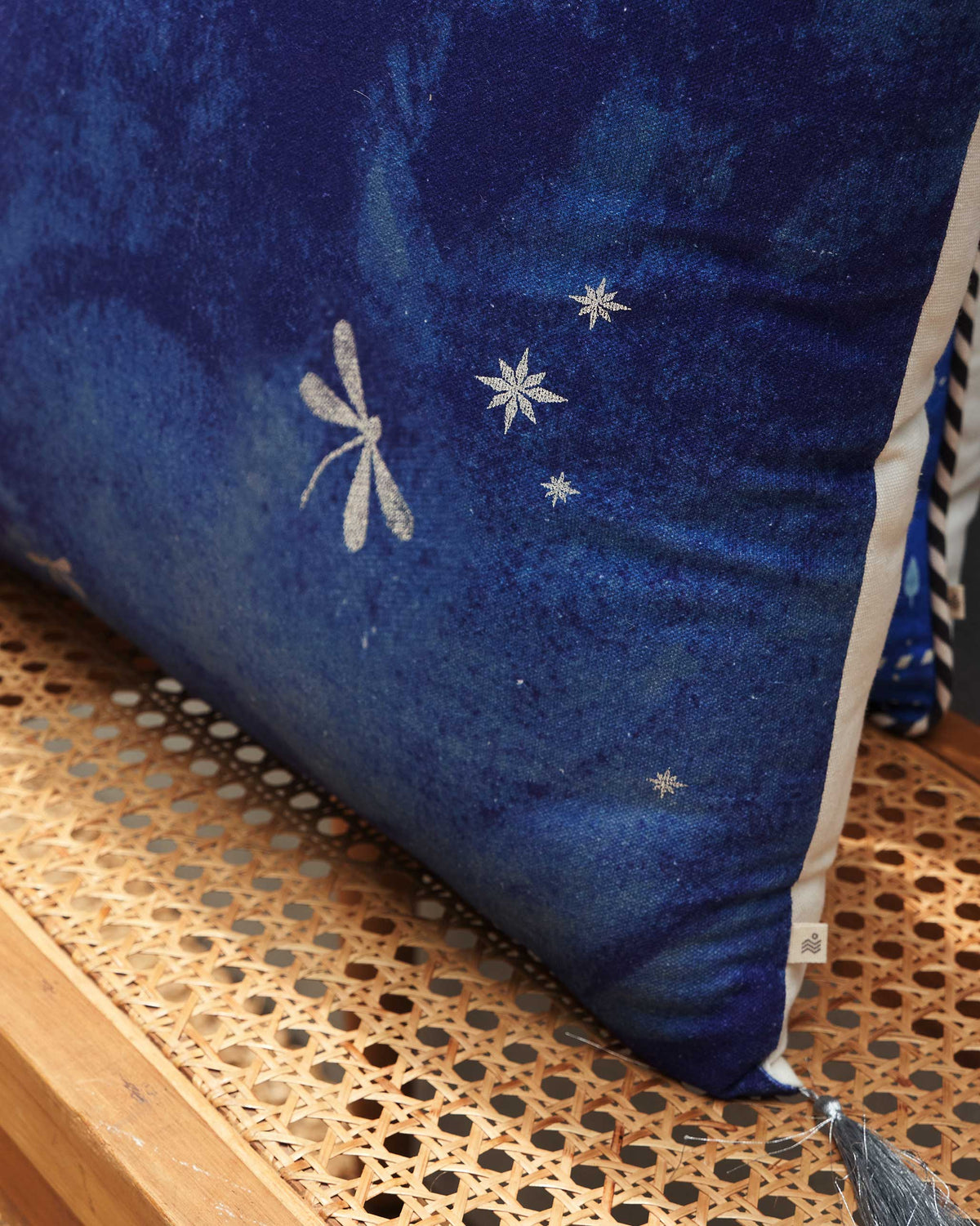 Side view of Azraq dragonfly cushion cover with silver dragonflies and stars.