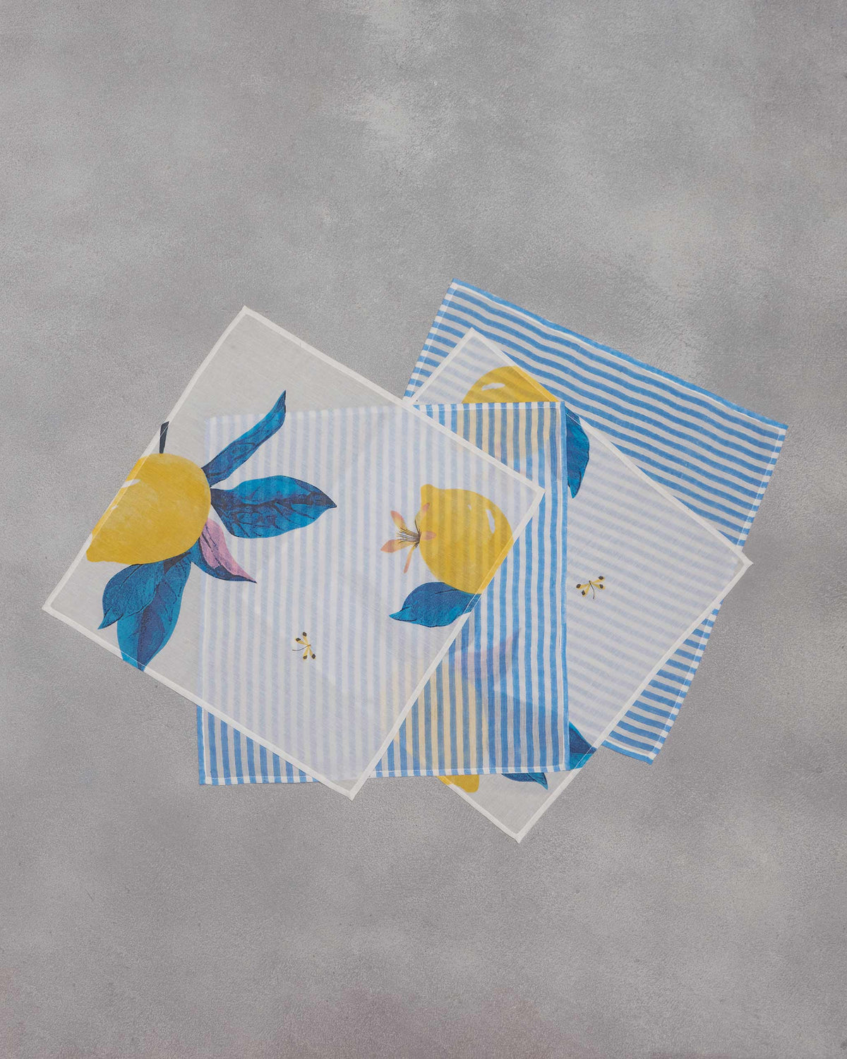 Set of four Azraq napkins with lemon print and blue stripes.