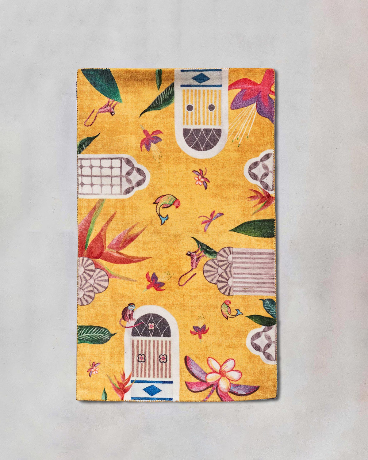 Yellow Mandovi rug with birds and flowers laid flat.