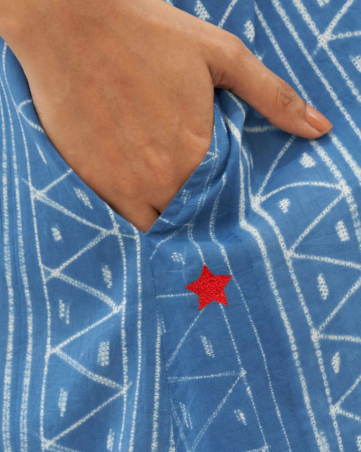 Close-up of the blue strappy dress pocket with a small red embroidered star.