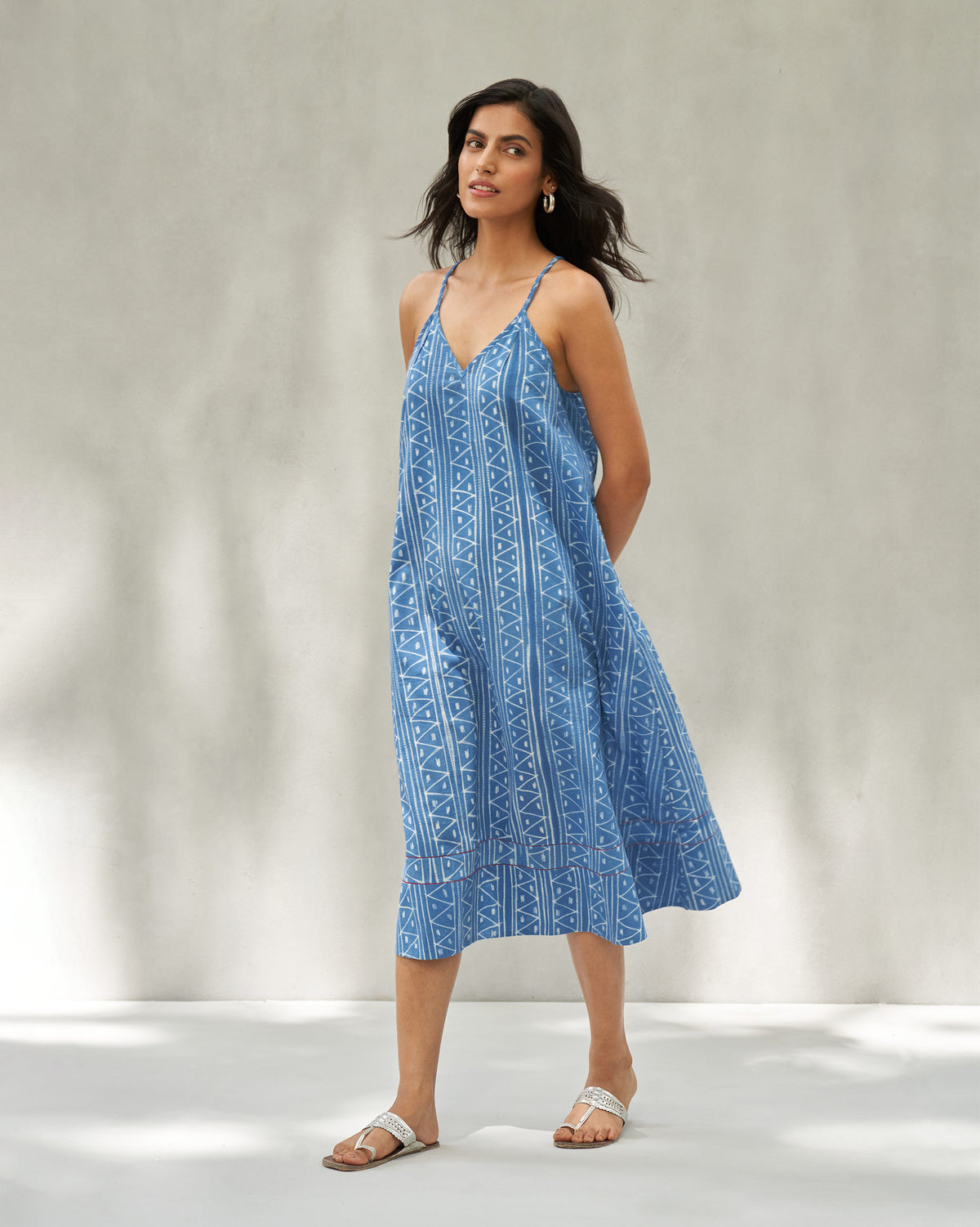 Blue strappy midi dress with white geometric print showing a flared A-line shape.