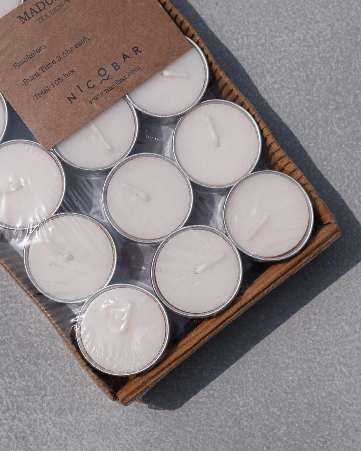 Close-up of Madurai tealight pack with Nicobar label on clear wrap.