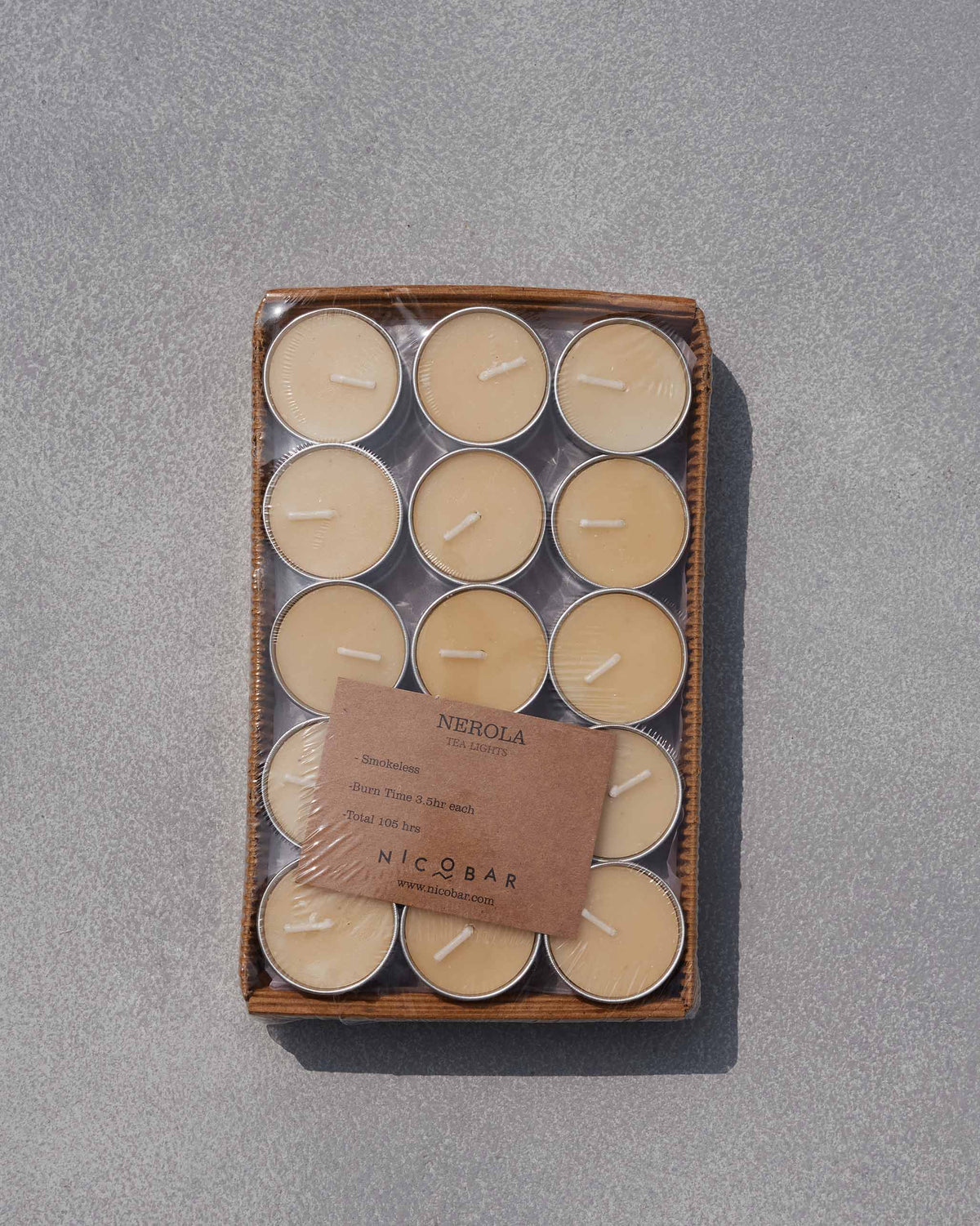 Pack of cream Nerola tealights in silver cups with a brown Nicobar label.