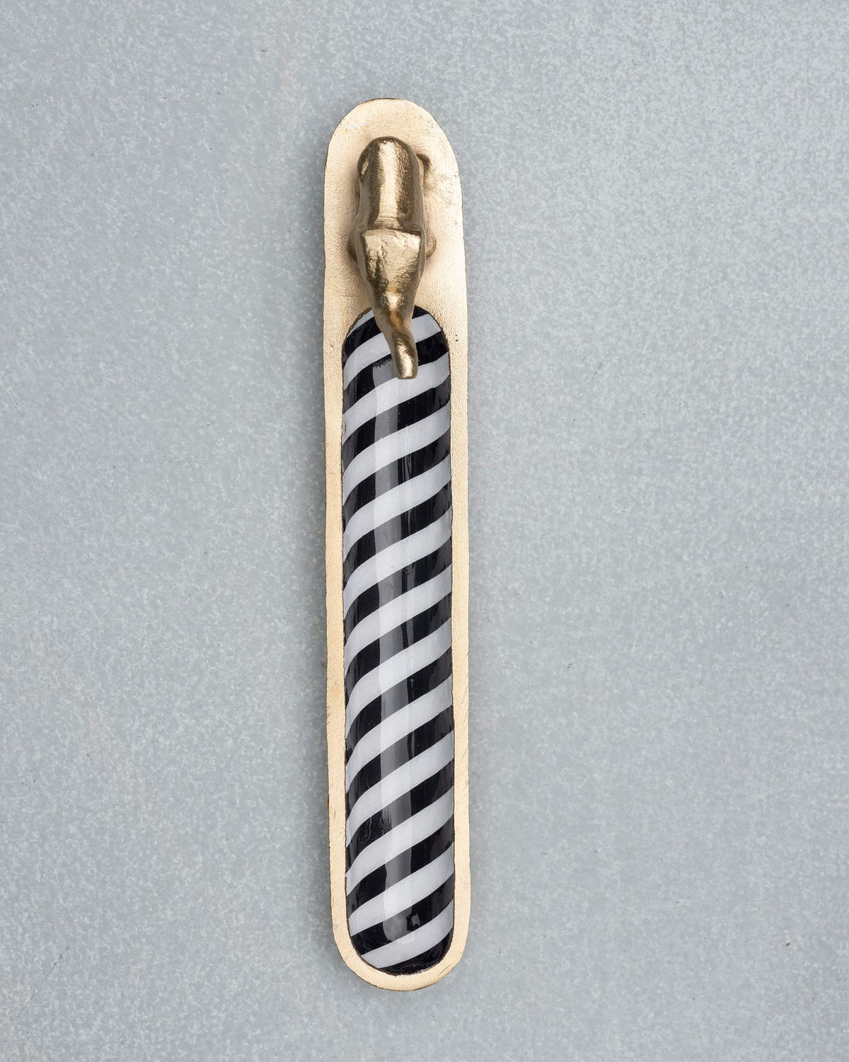 Overhead view of a brass Haathi incense holder with black and white stripes.